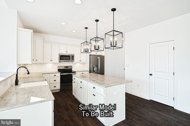 kitchen featuring appliances with stainless steel finishes, pendant lighting, a kitchen island, sink, and white cabinetry