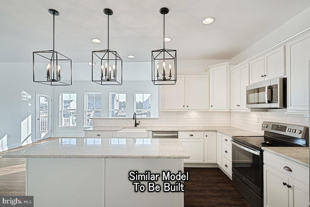 kitchen with light stone countertops, appliances with stainless steel finishes, and white cabinets