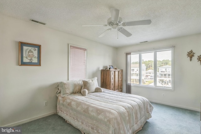 carpeted bedroom with a textured ceiling and ceiling fan