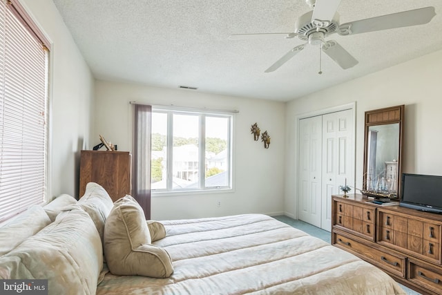 bedroom featuring a closet, a textured ceiling, and ceiling fan