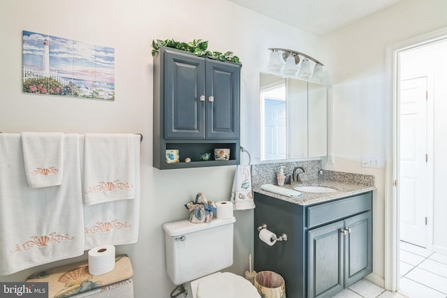 bathroom with tile patterned flooring, vanity, and toilet