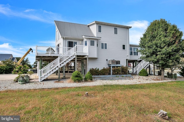 rear view of property featuring a yard, a wooden deck, and cooling unit