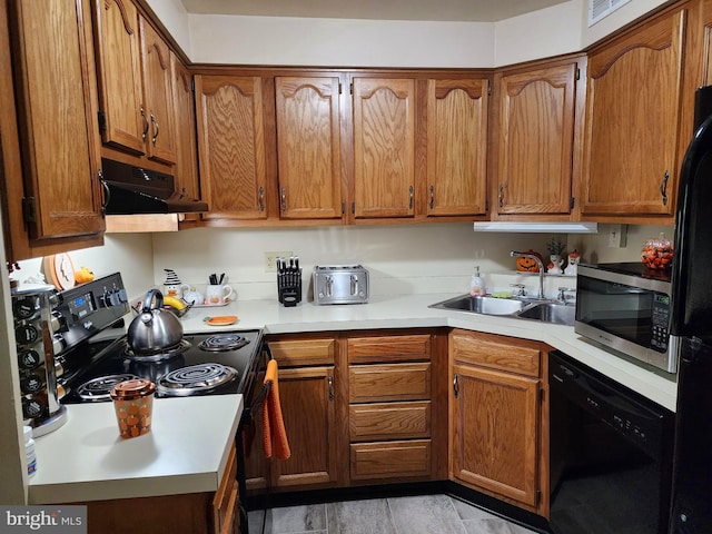 kitchen with black appliances, sink, light hardwood / wood-style floors, and exhaust hood