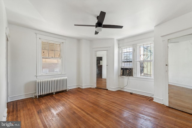 interior space with wood-type flooring, cooling unit, radiator heating unit, and ceiling fan