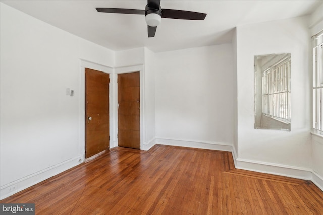 empty room with ceiling fan and hardwood / wood-style floors