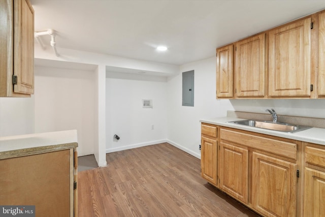 clothes washing area with light hardwood / wood-style flooring, electric panel, hookup for a washing machine, and sink