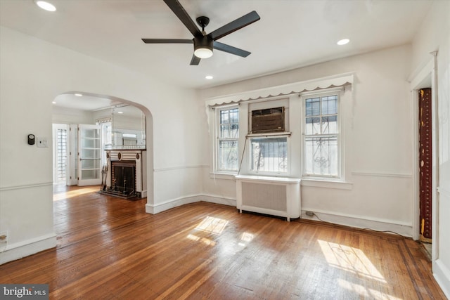 spare room featuring hardwood / wood-style floors, ceiling fan, and radiator heating unit