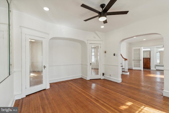 interior space with radiator heating unit, hardwood / wood-style flooring, and ceiling fan