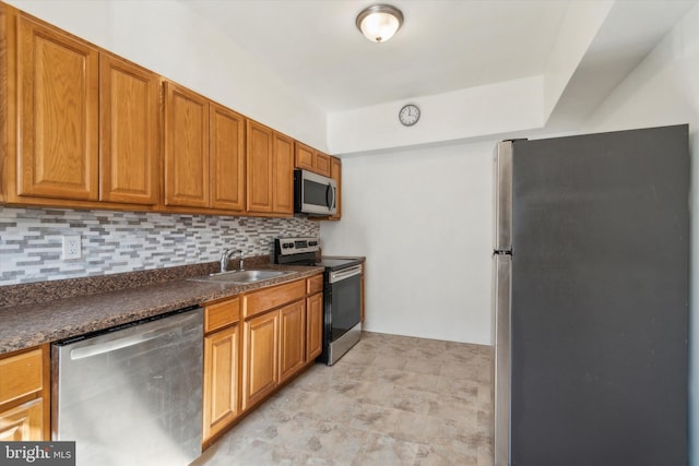 kitchen with dark stone countertops, sink, stainless steel appliances, and tasteful backsplash