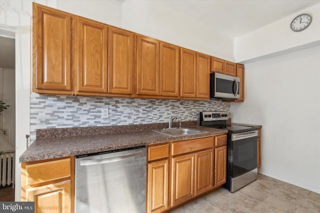 kitchen with appliances with stainless steel finishes, decorative backsplash, and sink