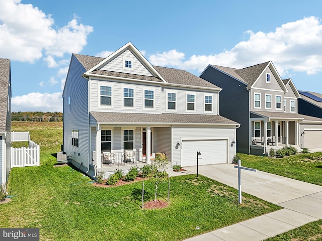 view of front of property featuring a garage, a front lawn, and a porch