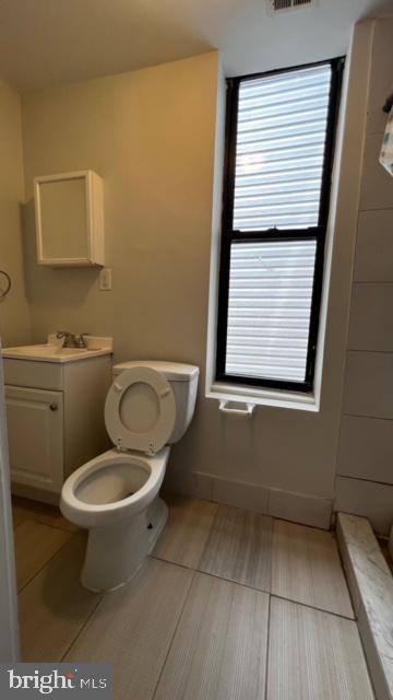 bathroom with vanity, visible vents, toilet, wood finished floors, and baseboards