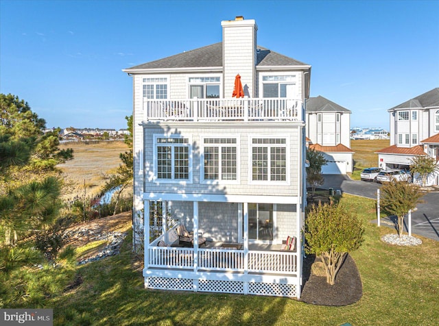 back of house featuring a yard and a sunroom