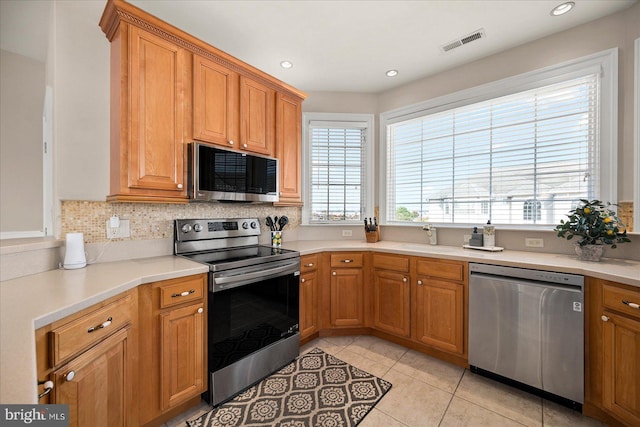 kitchen with sink, decorative backsplash, appliances with stainless steel finishes, and light tile patterned floors