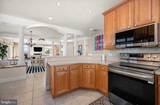 kitchen with kitchen peninsula, light tile patterned floors, appliances with stainless steel finishes, backsplash, and a chandelier