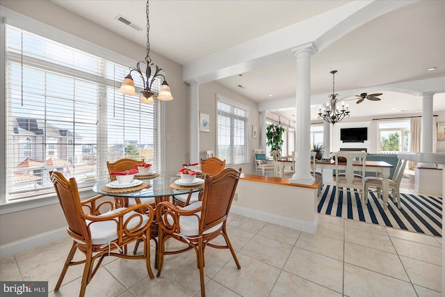 dining area featuring ornate columns, light tile patterned floors, ceiling fan with notable chandelier, and a wealth of natural light