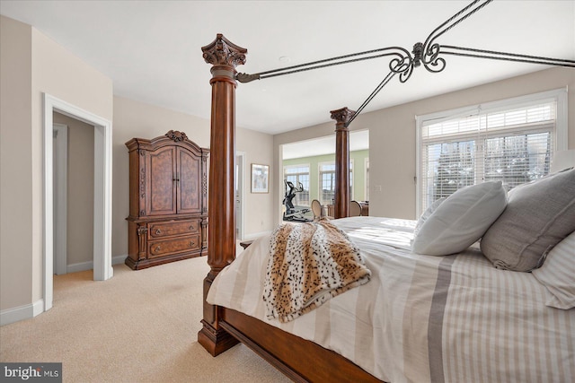 carpeted bedroom with decorative columns and multiple windows