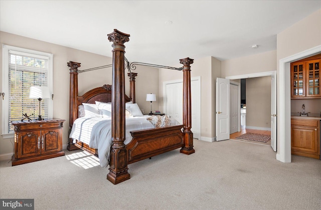 bedroom featuring light carpet and sink