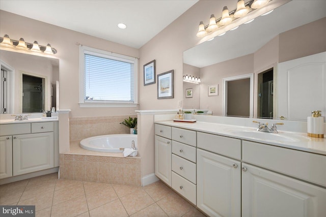 bathroom with vanity, tiled tub, and tile patterned floors