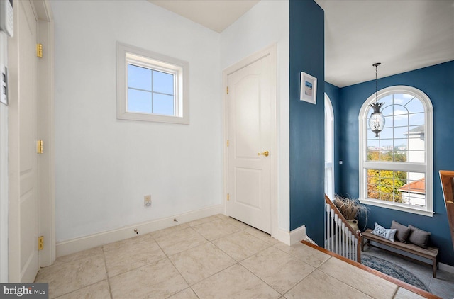 entryway with a chandelier and light tile patterned floors