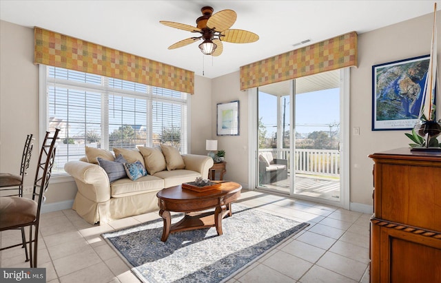 tiled living room with plenty of natural light and ceiling fan