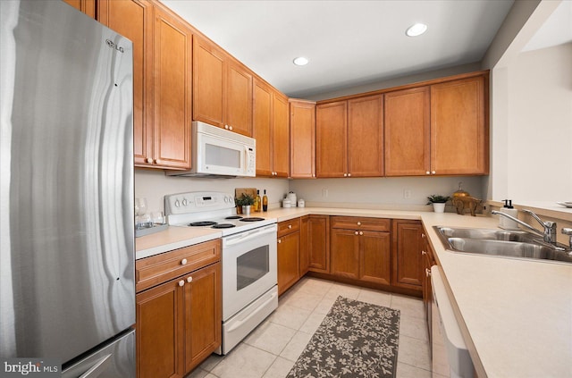 kitchen with sink, light tile patterned floors, and white appliances