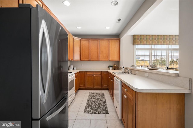 kitchen featuring kitchen peninsula, sink, light tile patterned floors, and white appliances