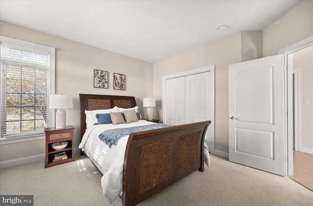 bedroom featuring a closet, multiple windows, and light colored carpet