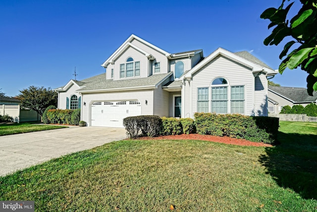 traditional home with driveway, fence, and a front lawn