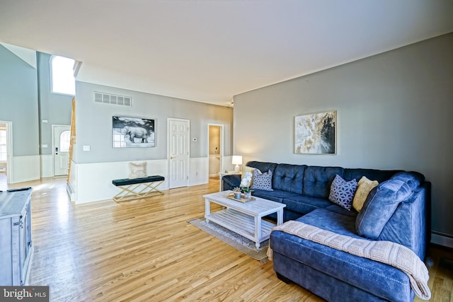 living room with wainscoting, visible vents, and wood finished floors
