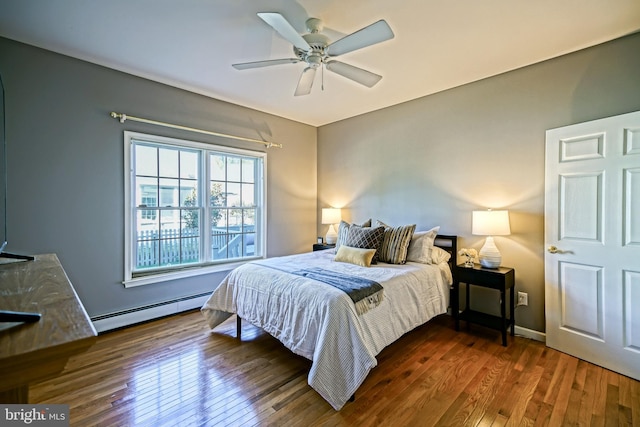 bedroom with ceiling fan, a baseboard radiator, and dark hardwood / wood-style floors