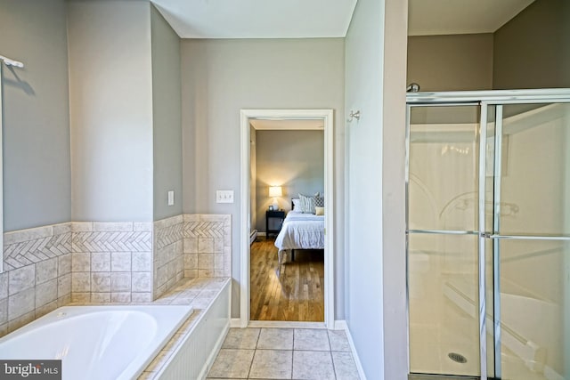 ensuite bathroom featuring tile patterned floors, a bath, a shower stall, and connected bathroom