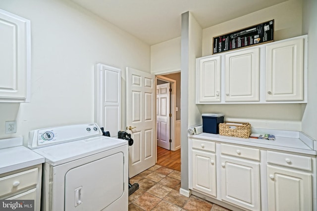 clothes washing area featuring light wood-type flooring, washer / clothes dryer, and cabinets