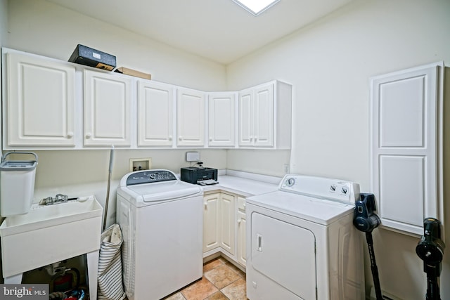 laundry room with cabinet space, washer and dryer, and a sink
