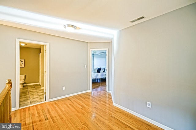 empty room featuring visible vents, baseboards, and light wood finished floors
