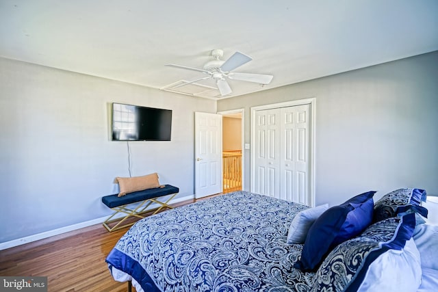 bedroom with ceiling fan, a closet, baseboards, and wood finished floors