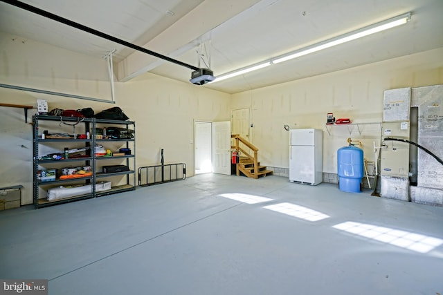 garage with a garage door opener and freestanding refrigerator