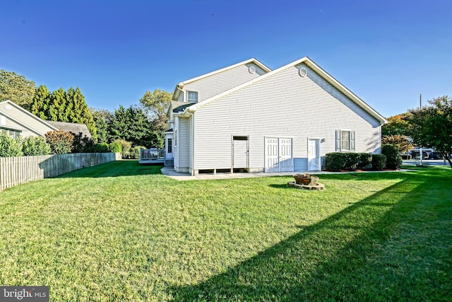 back of property with a yard and fence