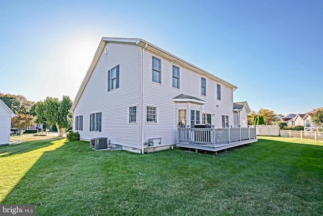 back of property with a yard, central AC, a wooden deck, and fence