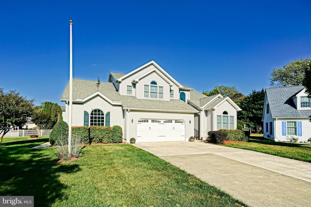 traditional-style home featuring concrete driveway, a garage, fence, and a front lawn