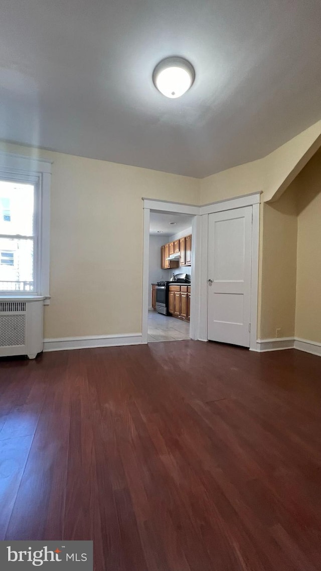 unfurnished room with radiator and dark hardwood / wood-style floors