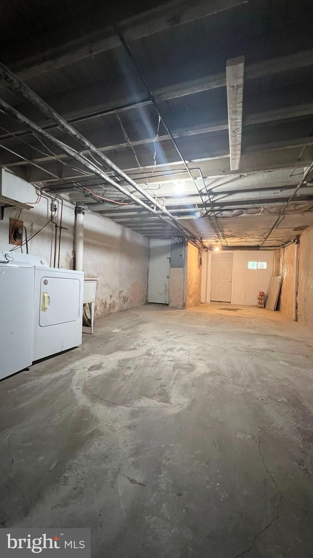 basement with electric panel and washing machine and dryer