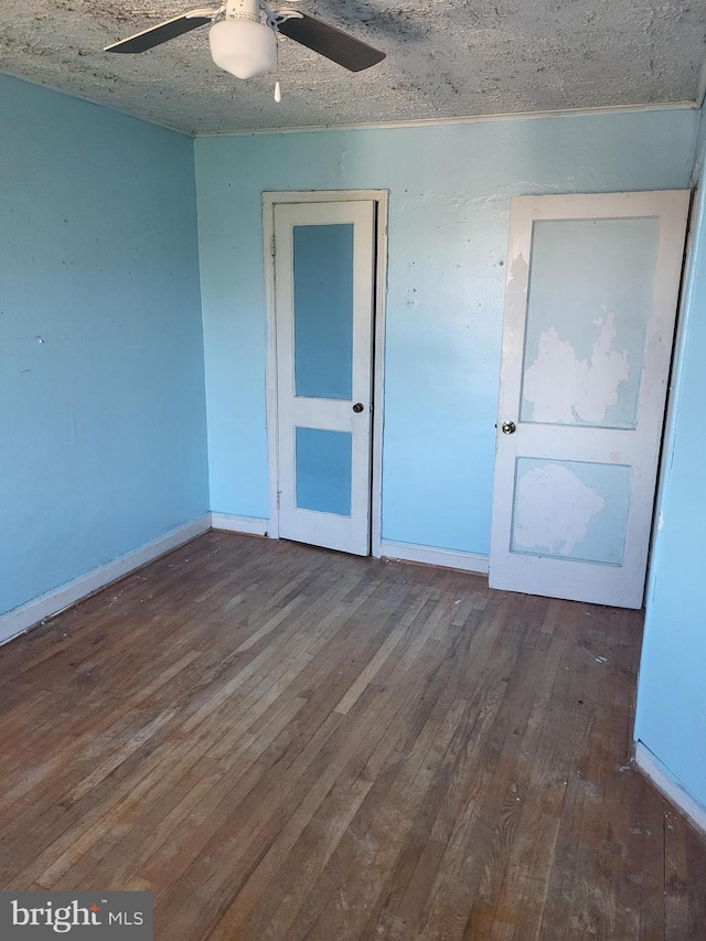 unfurnished room with baseboards, ceiling fan, a textured ceiling, and hardwood / wood-style floors