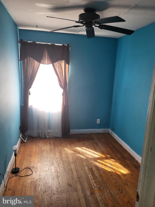 unfurnished room featuring wood-type flooring and baseboards