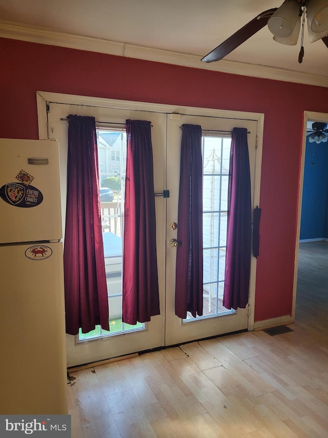 doorway to outside with ornamental molding, plenty of natural light, and a ceiling fan