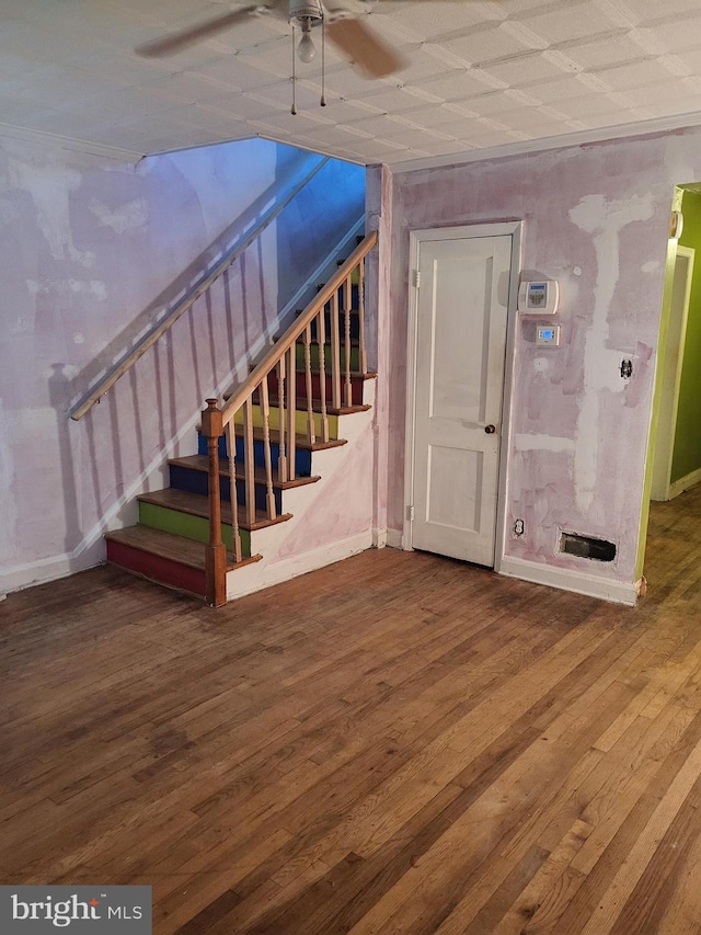 stairway with a ceiling fan, baseboards, and wood finished floors