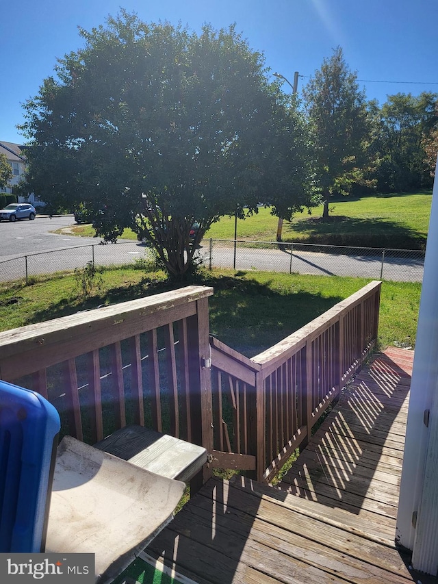 wooden deck featuring a lawn and fence