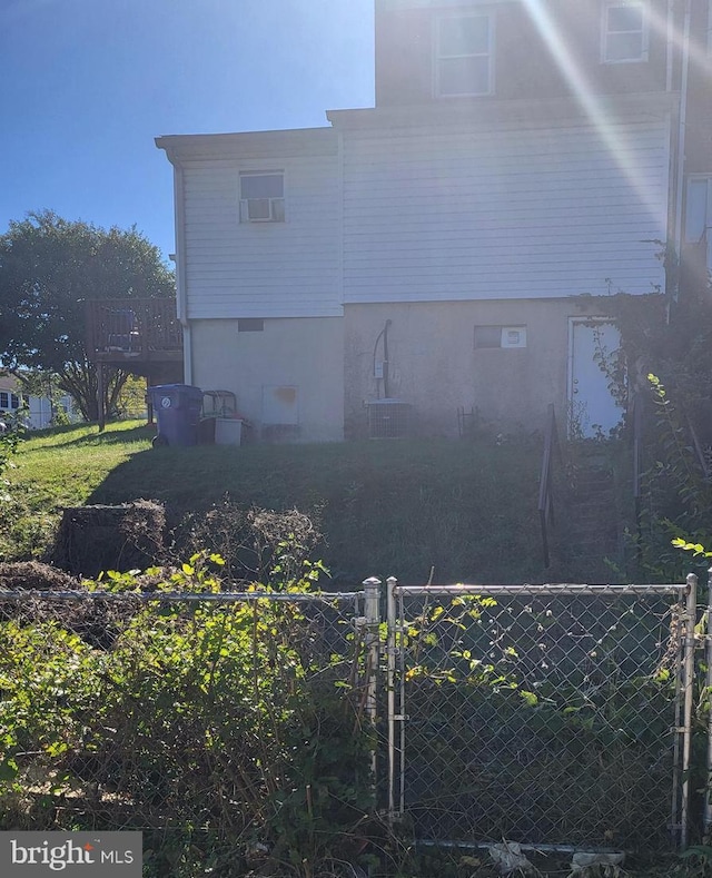 view of property exterior with crawl space, a gate, and fence