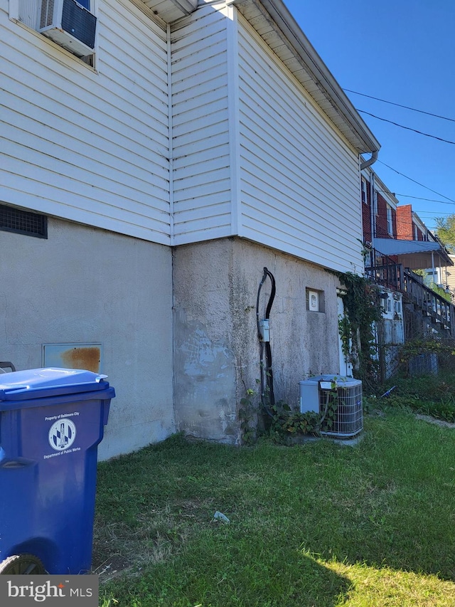 view of property exterior featuring central AC, a lawn, and stucco siding