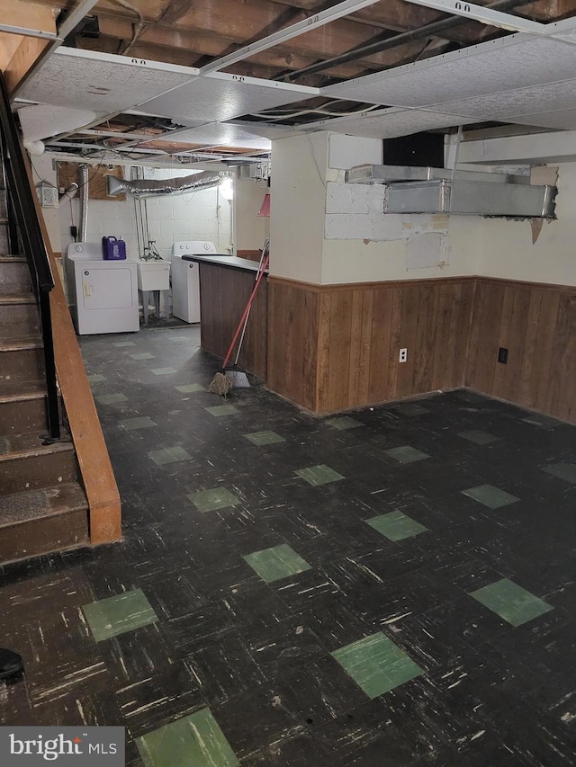 unfinished below grade area featuring washer / dryer, wainscoting, and tile patterned floors